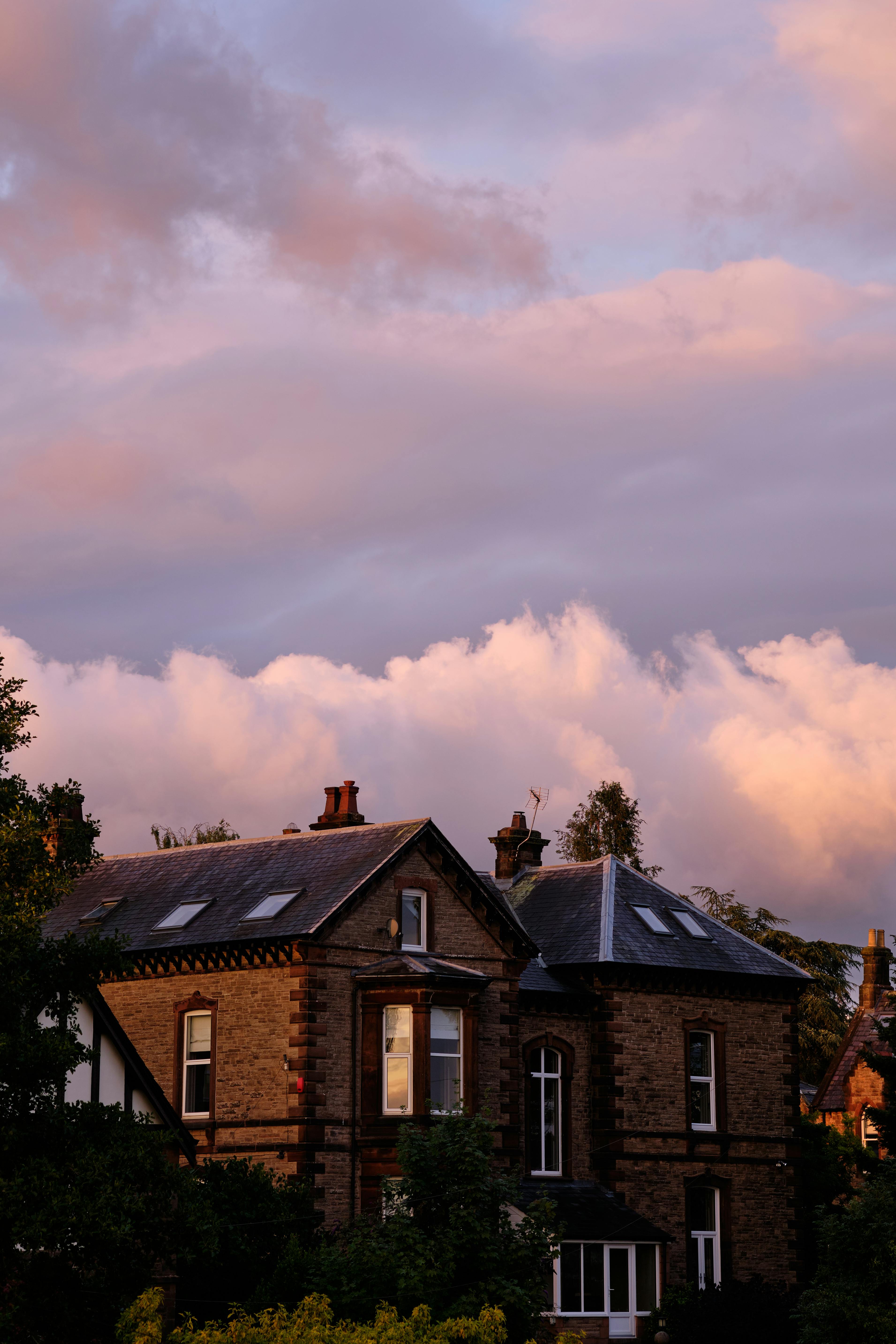 A scenic view of redbrick houses in Penrith, England, silhouetted against a beautiful sunset sky.
