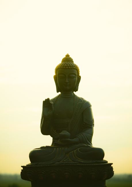 A serene silhouette of a Buddha statue against a dusk sky, symbolizing peace and spirituality.