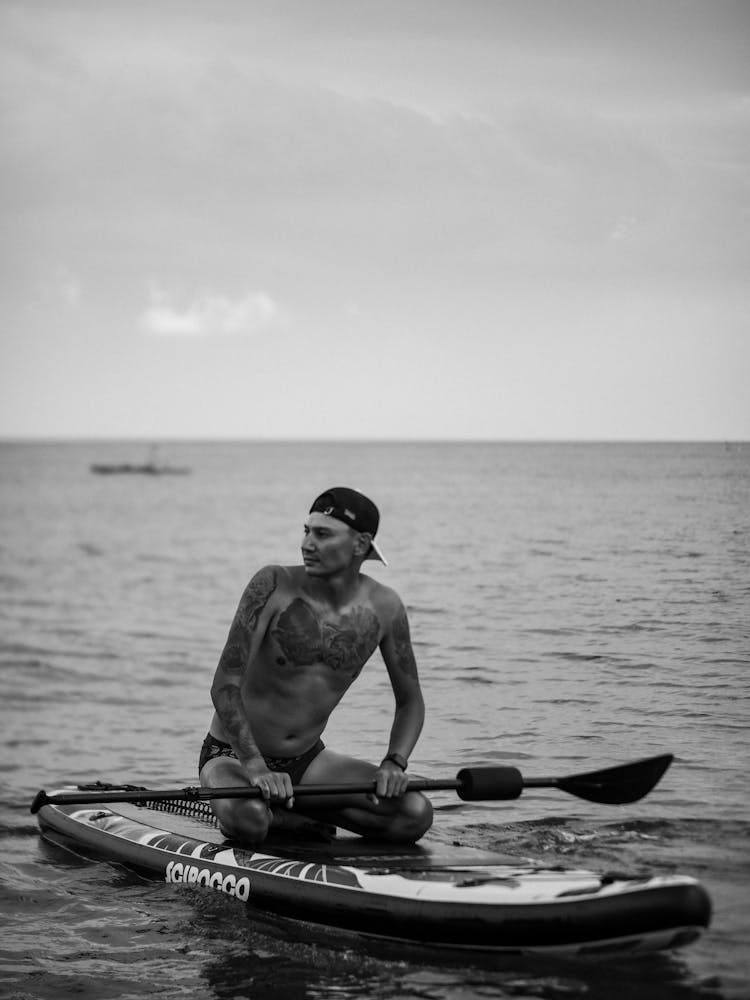 Man Kneeling On Paddleboard