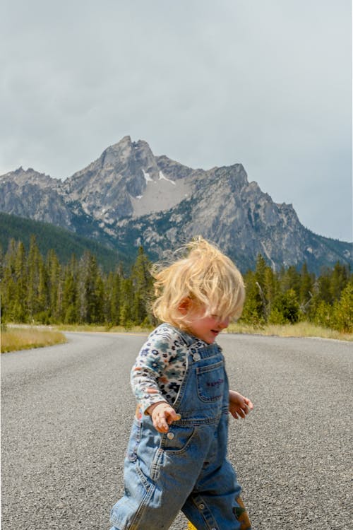 Blonde Child on Road in Mountains