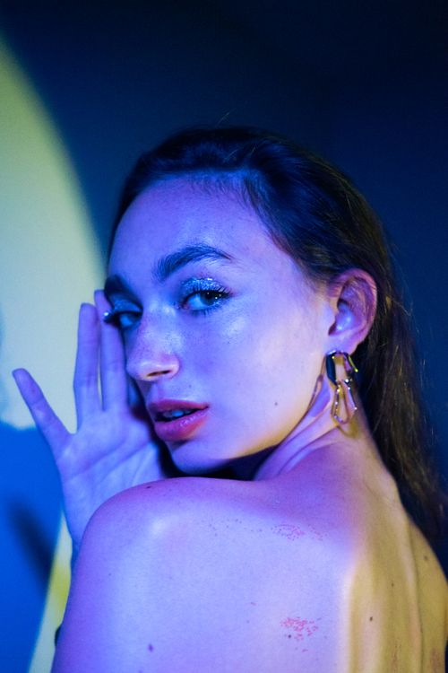 Free Artistic portrait of a woman with glitter makeup and earrings under colorful lighting, Bangkok, Thailand. Stock Photo
