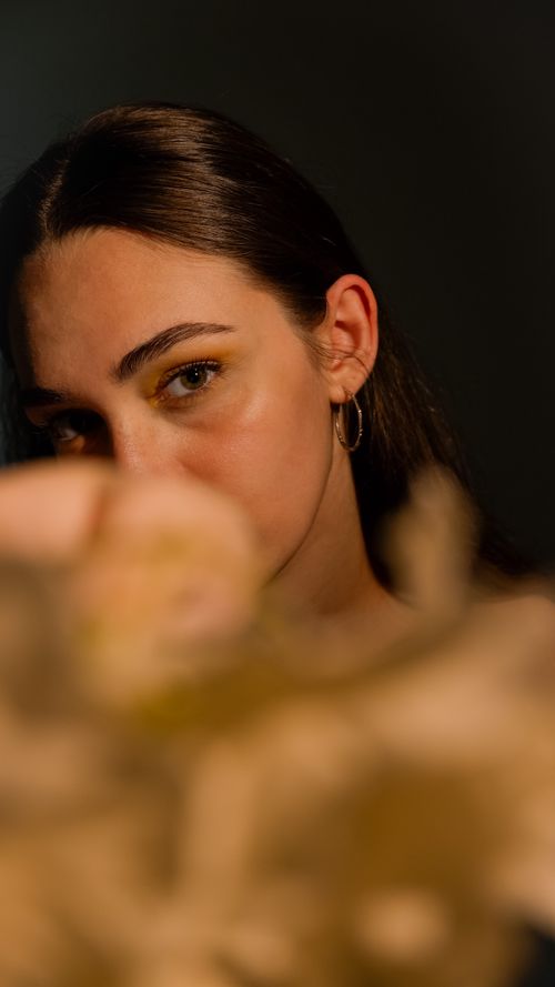 Free Artistic portrait focusing on woman's face with earring, using selective focus and warm lighting. Stock Photo