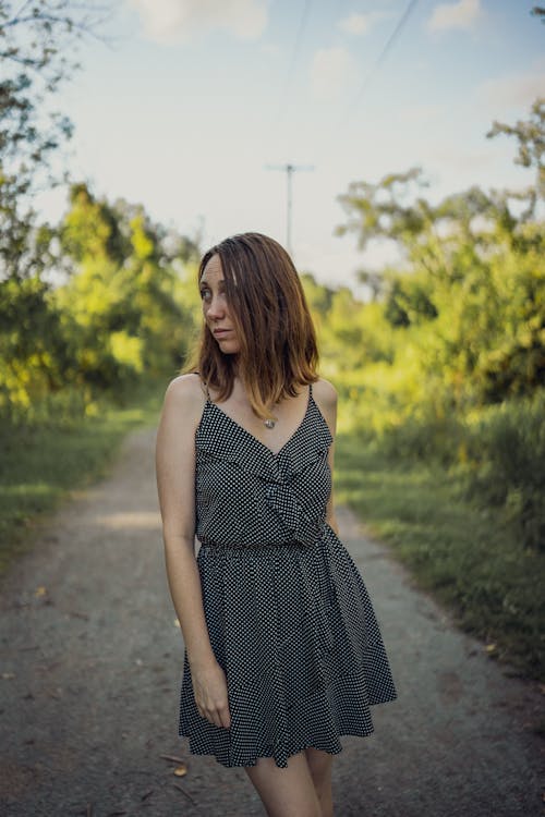 Woman in Sundress Standing on Footpath