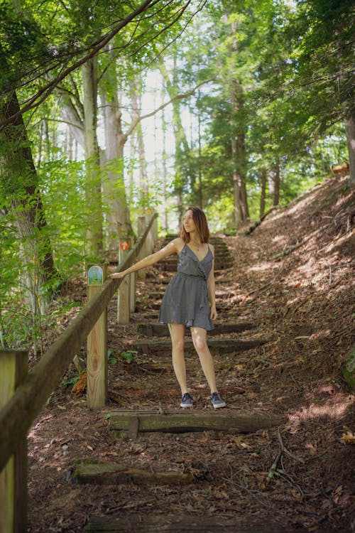 Young Woman in a Dress Standing in the Forest 