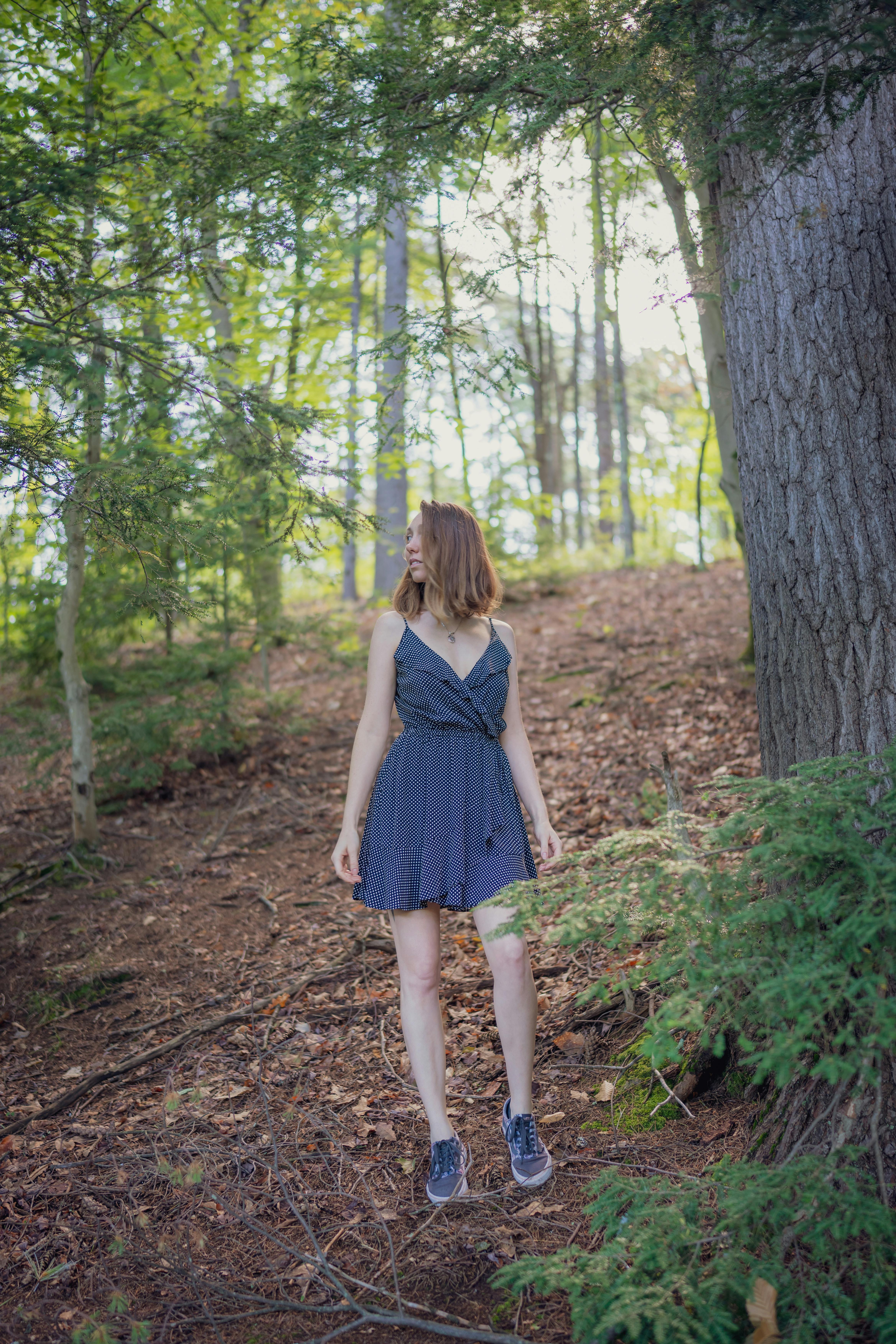 Free Young Woman in a Dress Standing in the Forest Stock Photo
