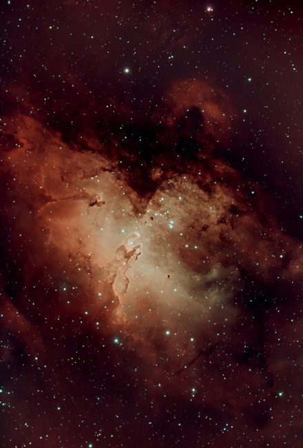 Captivating vertical shot of the Eagle Nebula, showcasing stellar gas and dust amidst stars.