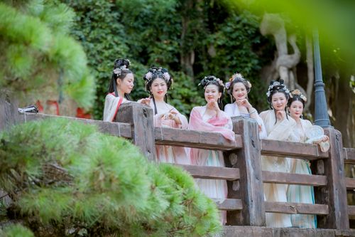 Free Women in traditional Japanese attire standing on a wooden bridge in a serene garden setting. Stock Photo