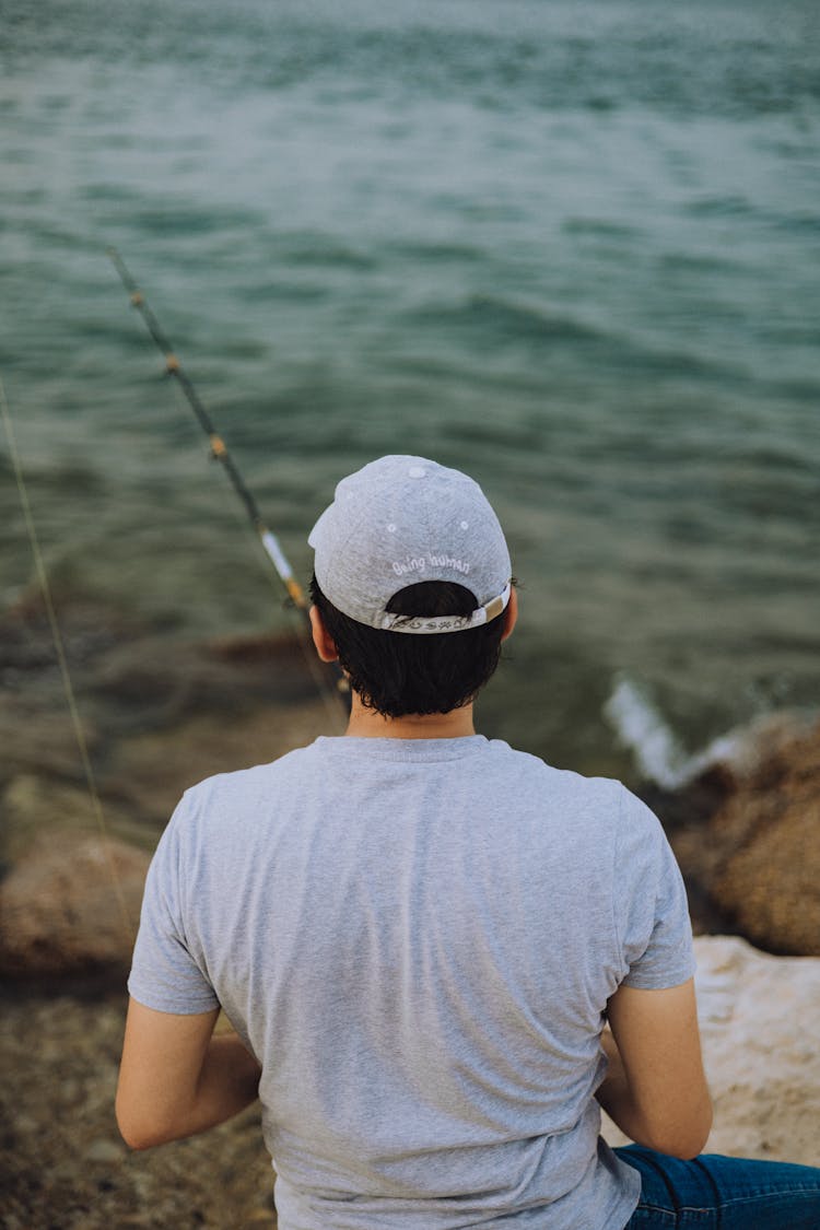 Back Of A Man Fishing At The Coast