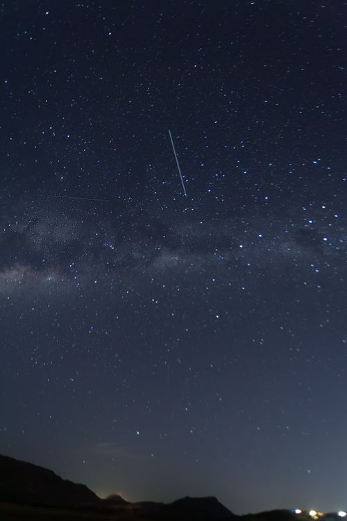 Free A mesmerizing view of the night sky featuring a shooting star amidst a galaxy of stars. Stock Photo