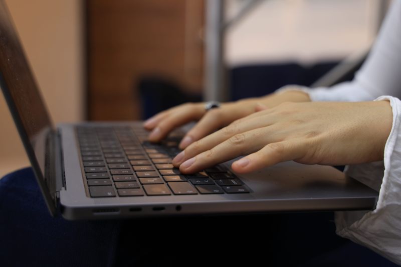 Hands typing on a laptop keyboard in an indoor setting. Perfect for business and technology themes.