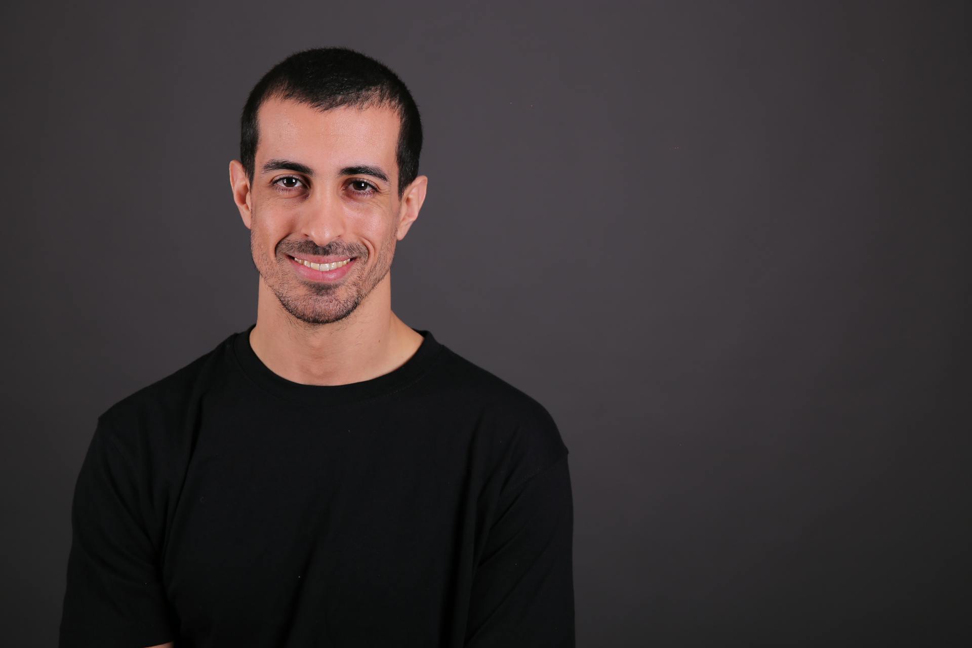 Business professional with a confident smile in a studio portrait setting.