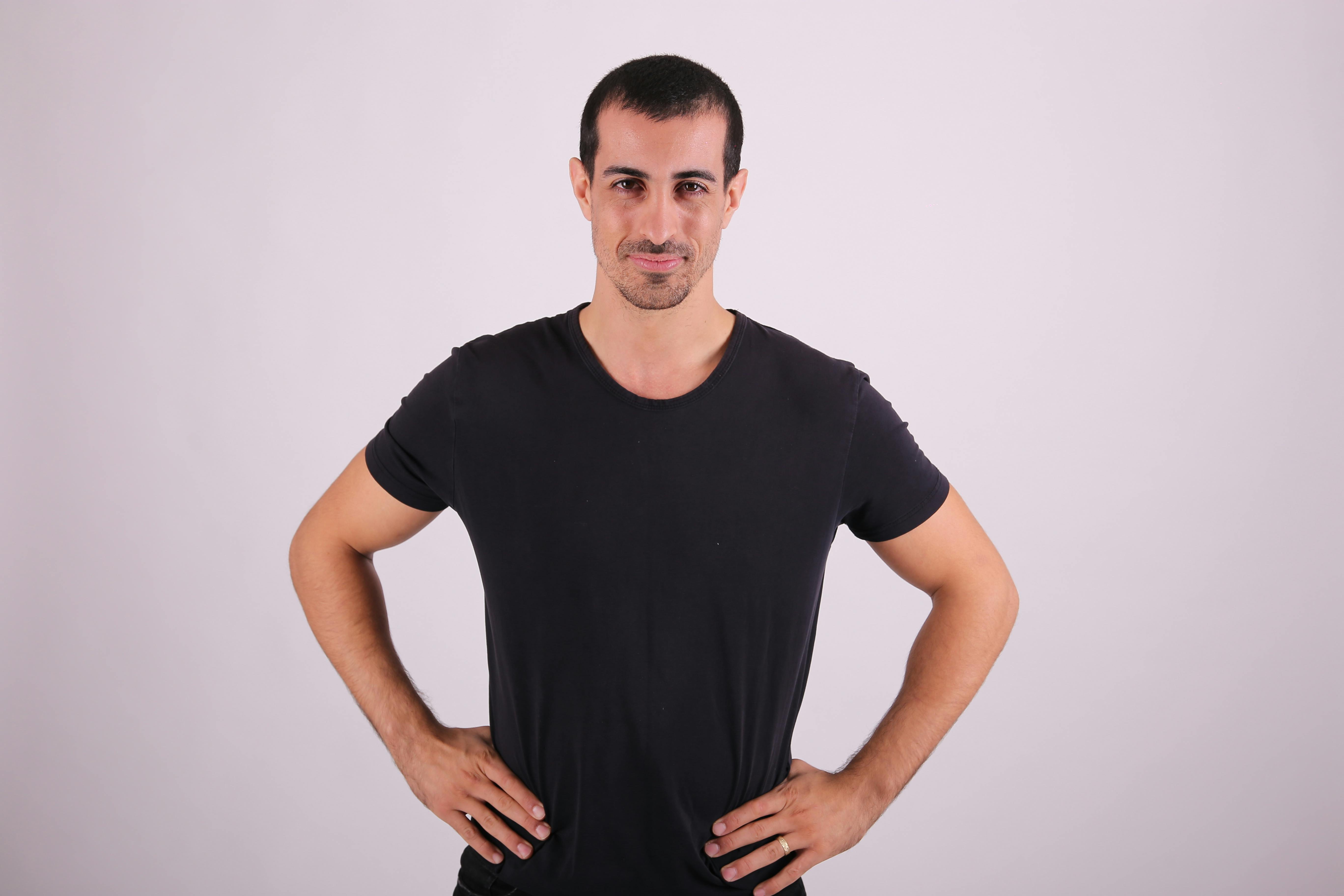 a man in a black t shirt standing with his hands on his hips