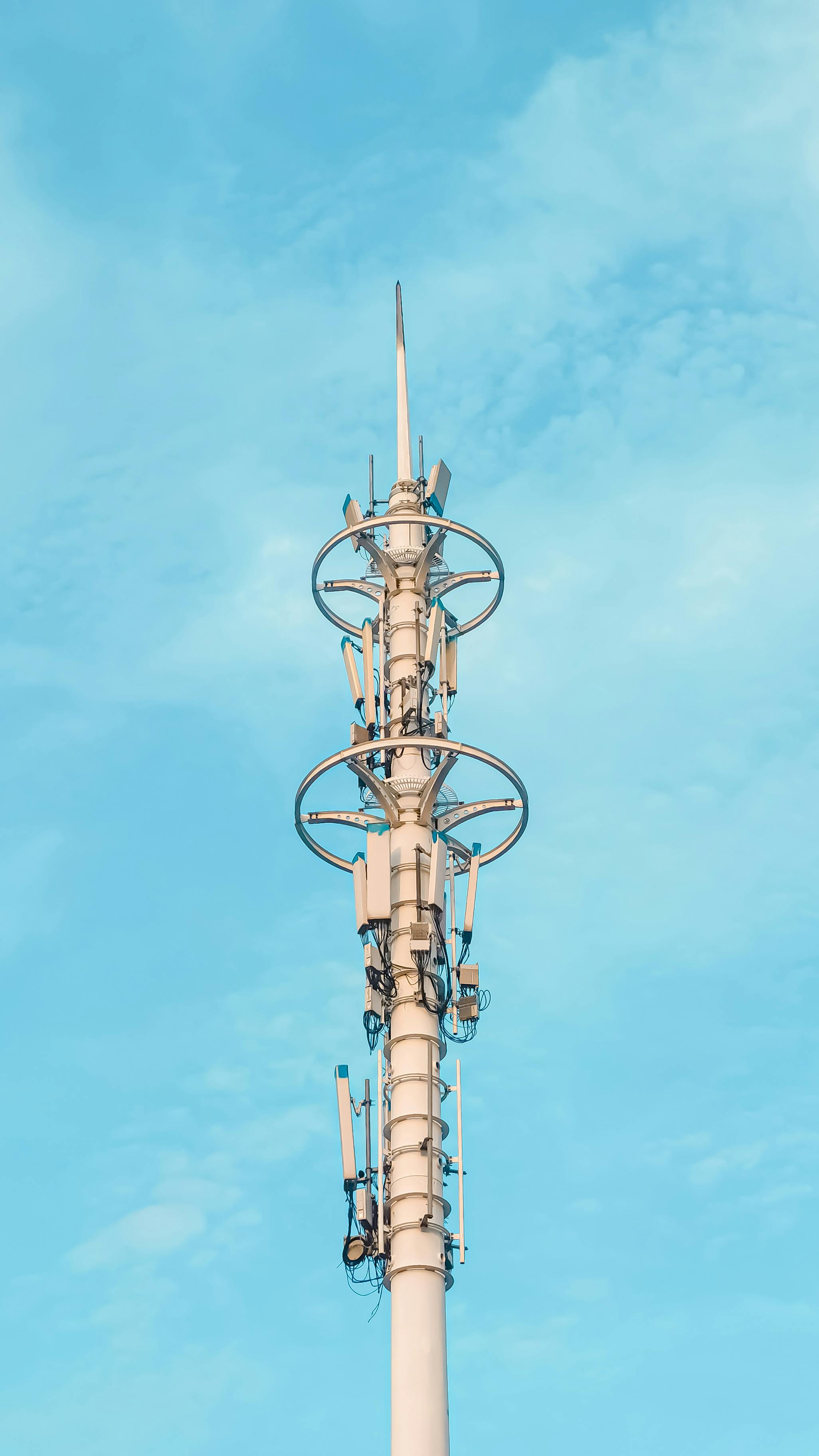 A tall antenna tower stands against a background of clear blue sky, showcasing modern communication equipment.