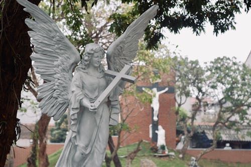 Religious Figurine of an Angel Holding a Cross on a Cemetery 