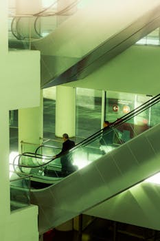 A view of people on escalators inside Amman airport terminal, featuring modern architecture.