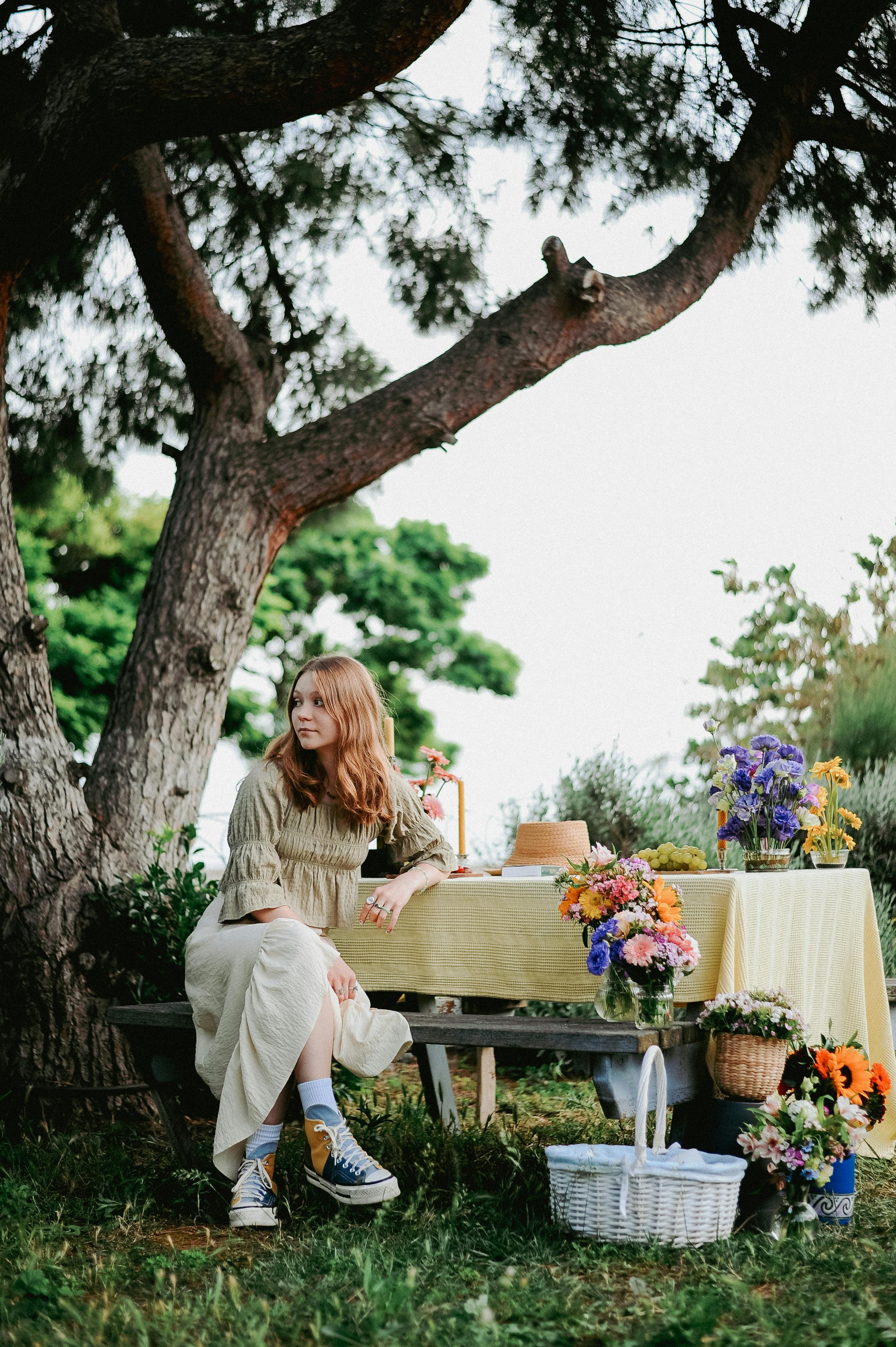 woman sitting by table under tree