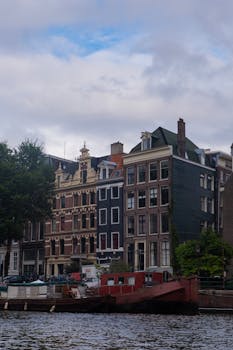 Picturesque Amsterdam canal with traditional Dutch architecture and houseboats.