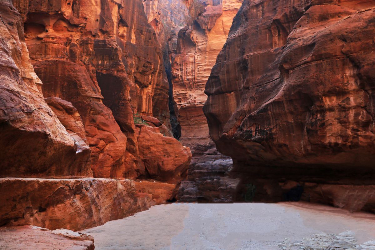 The narrow sandstone canyon of the Siq, its walls rising steeply on either side of a winding path