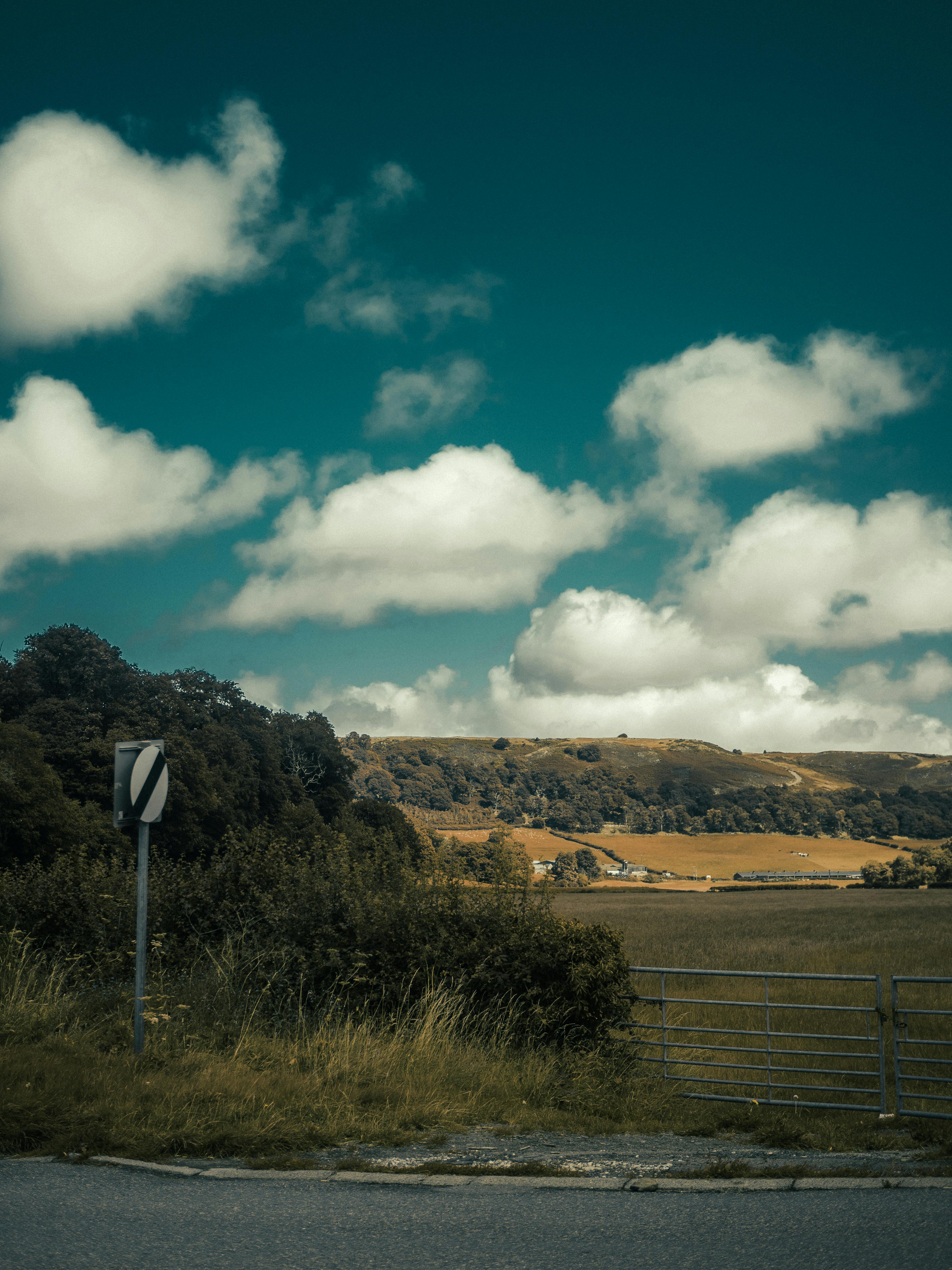 Explore the rolling hills and scenic countryside of Llanfair Talhaiarn, Wales, under a bright summer sky.