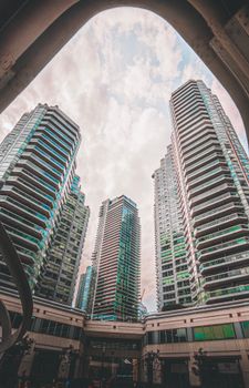 A stunning view of modern skyscrapers reaching towards the cloudy sky.