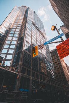 Modern skyscraper view from street level in downtown Toronto with street signs.