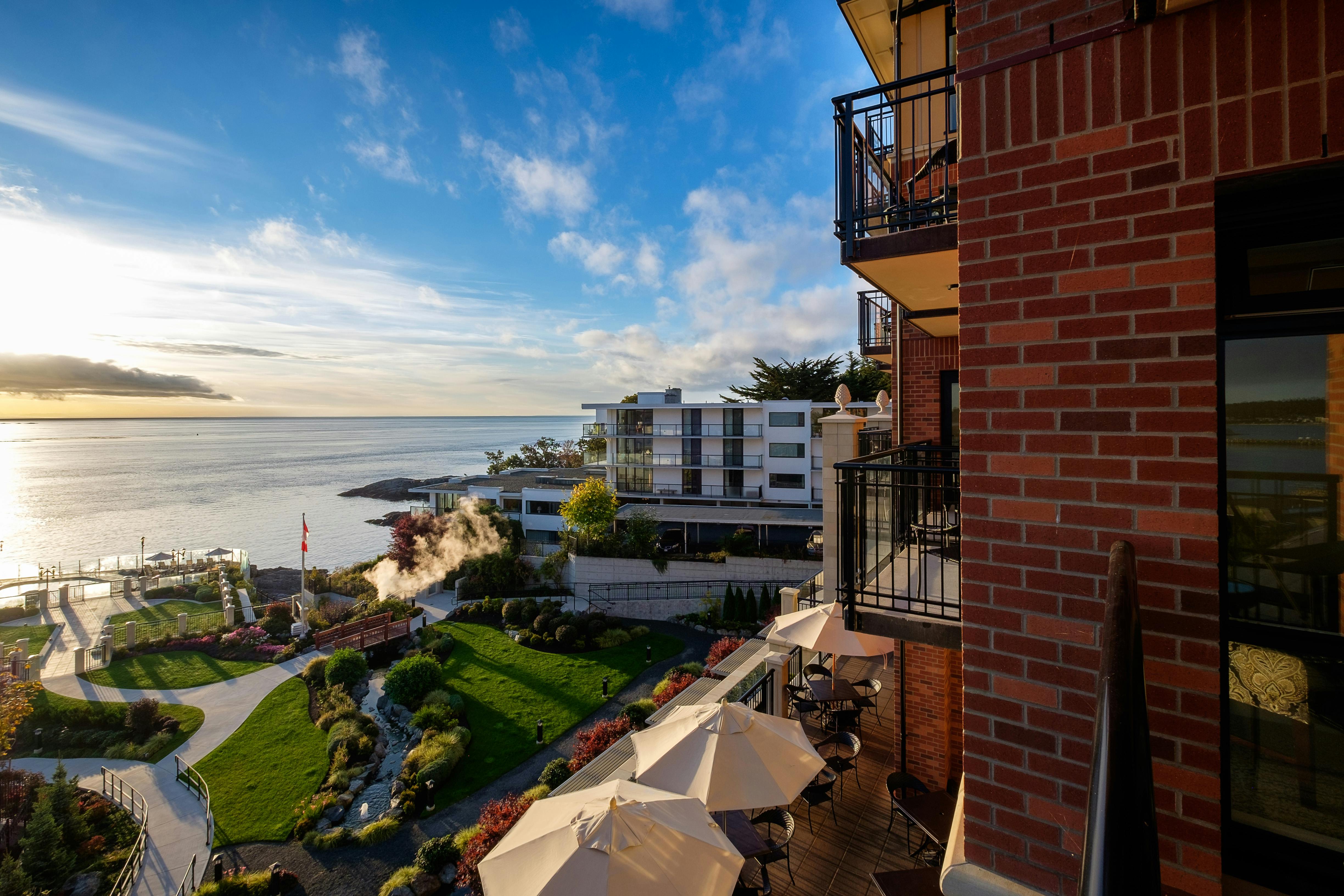 Beautiful modern waterfront residential area with stunning sunset and ocean view from a balcony.