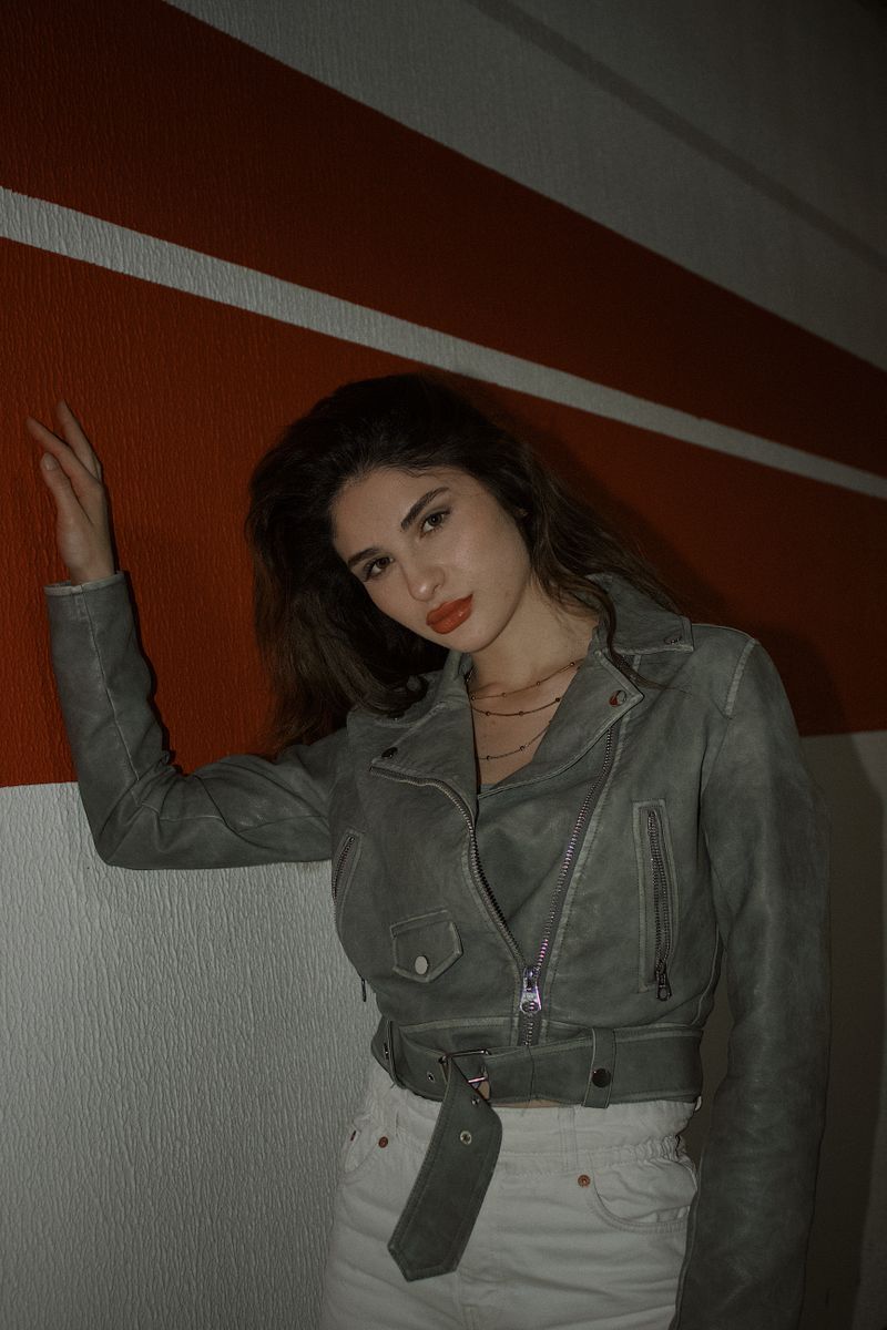 Woman in white jeans and leather jacket, casual date night outfit