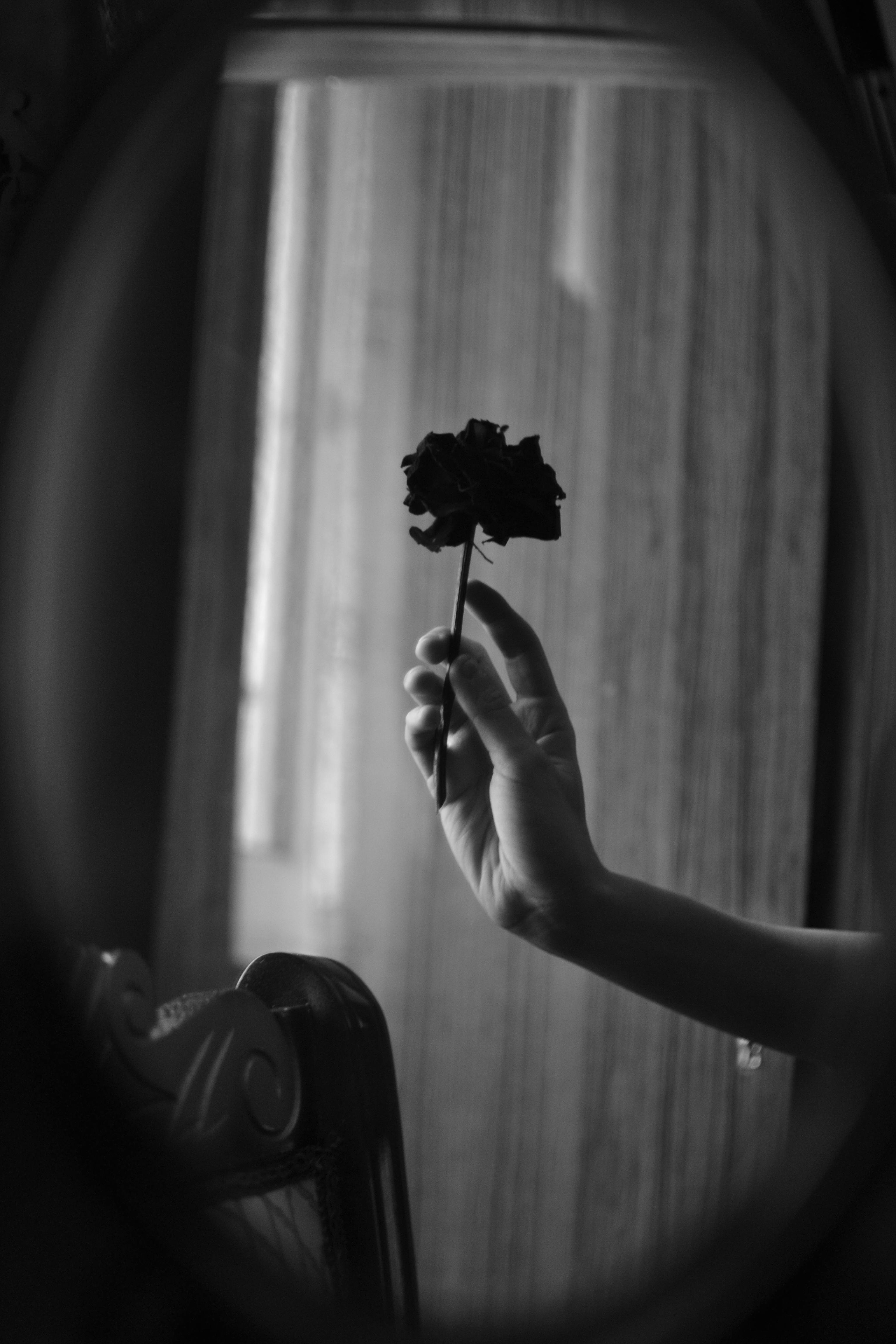 a black and white photo of a woman holding a flower