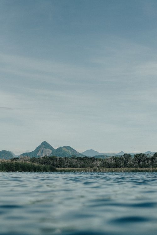 Free Peaceful landscape featuring a lake, mountains, and clear sky, perfect for nature lovers. Stock Photo
