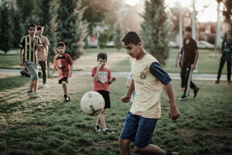 Boys Playing Football In Park