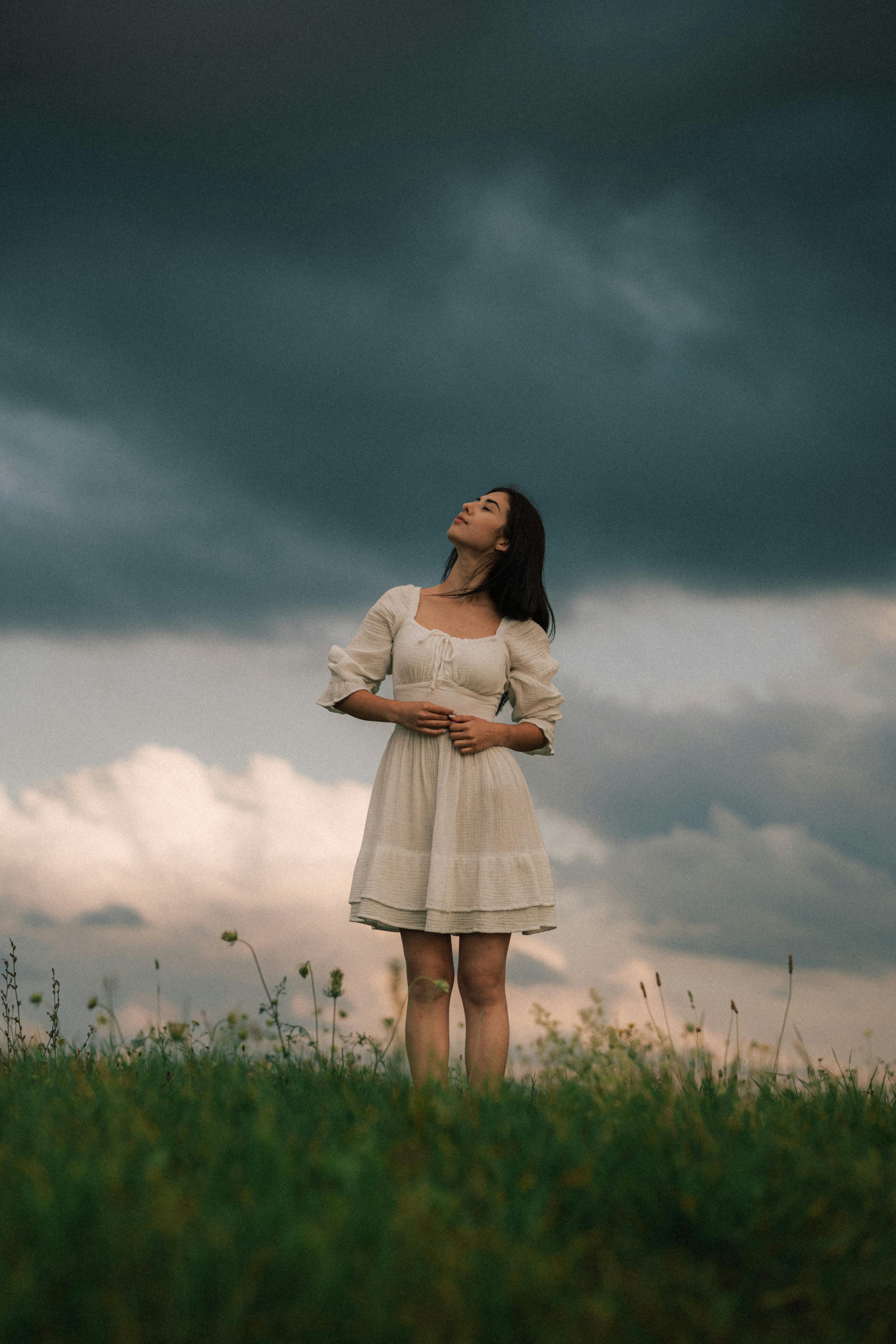 Woman in White Dress Standing on Meadow under Rain Cloud · Free Stock Photo