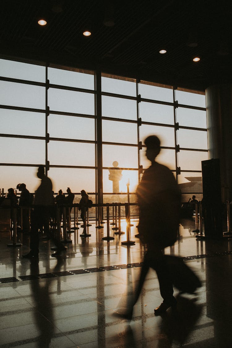 People Walking At Airport Terminal At Sunset