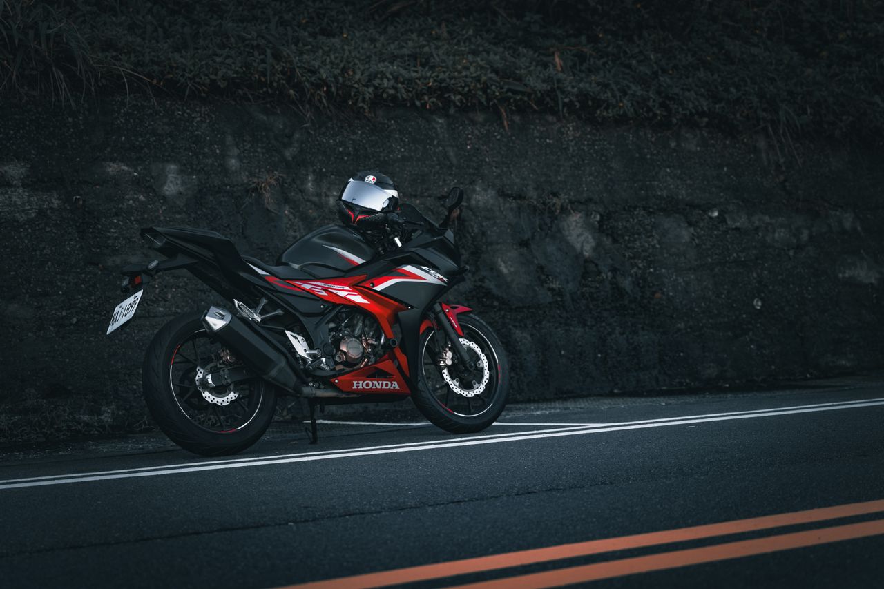 a red honda motorbike parked on a quiet roadside perfect for travel en