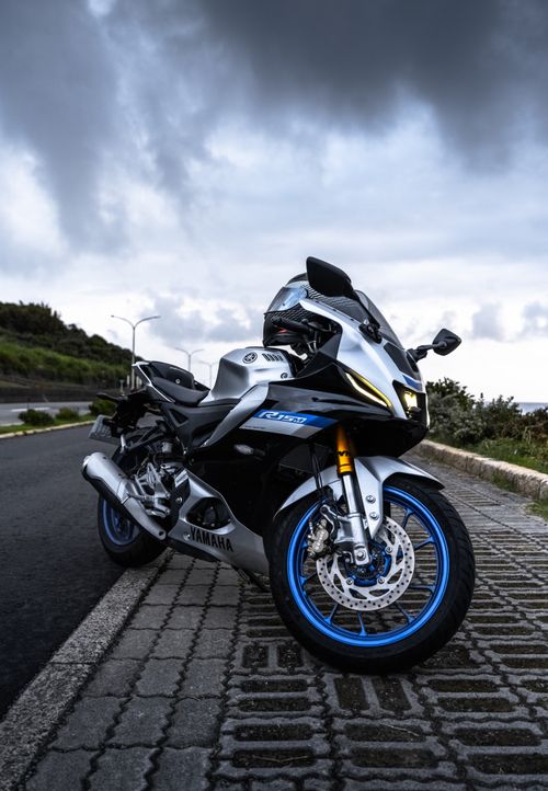 Free A sleek Yamaha sport bike parked on a scenic roadside under dramatic skies, exuding adventure. Stock Photo