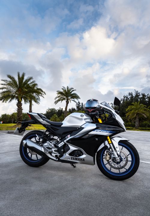 Free A stunning Yamaha motorcycle posed under palm trees against a vibrant sky. Stock Photo