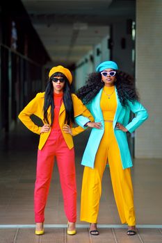 Fashionable women in colorful outfits posing confidently, showcasing contemporary style.