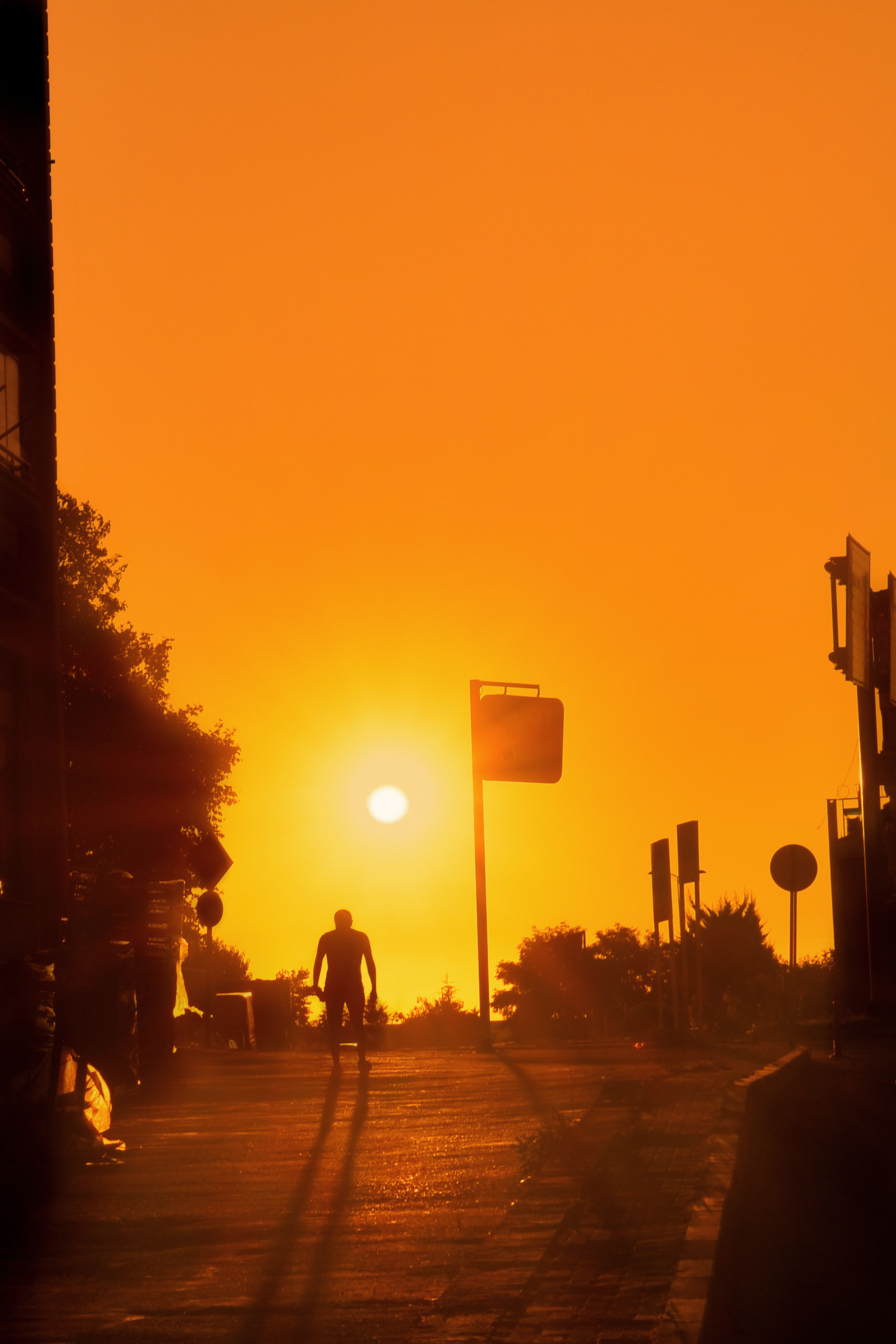 Silhouette of a Man Walking on a Street at Sunset · Free Stock Photo
