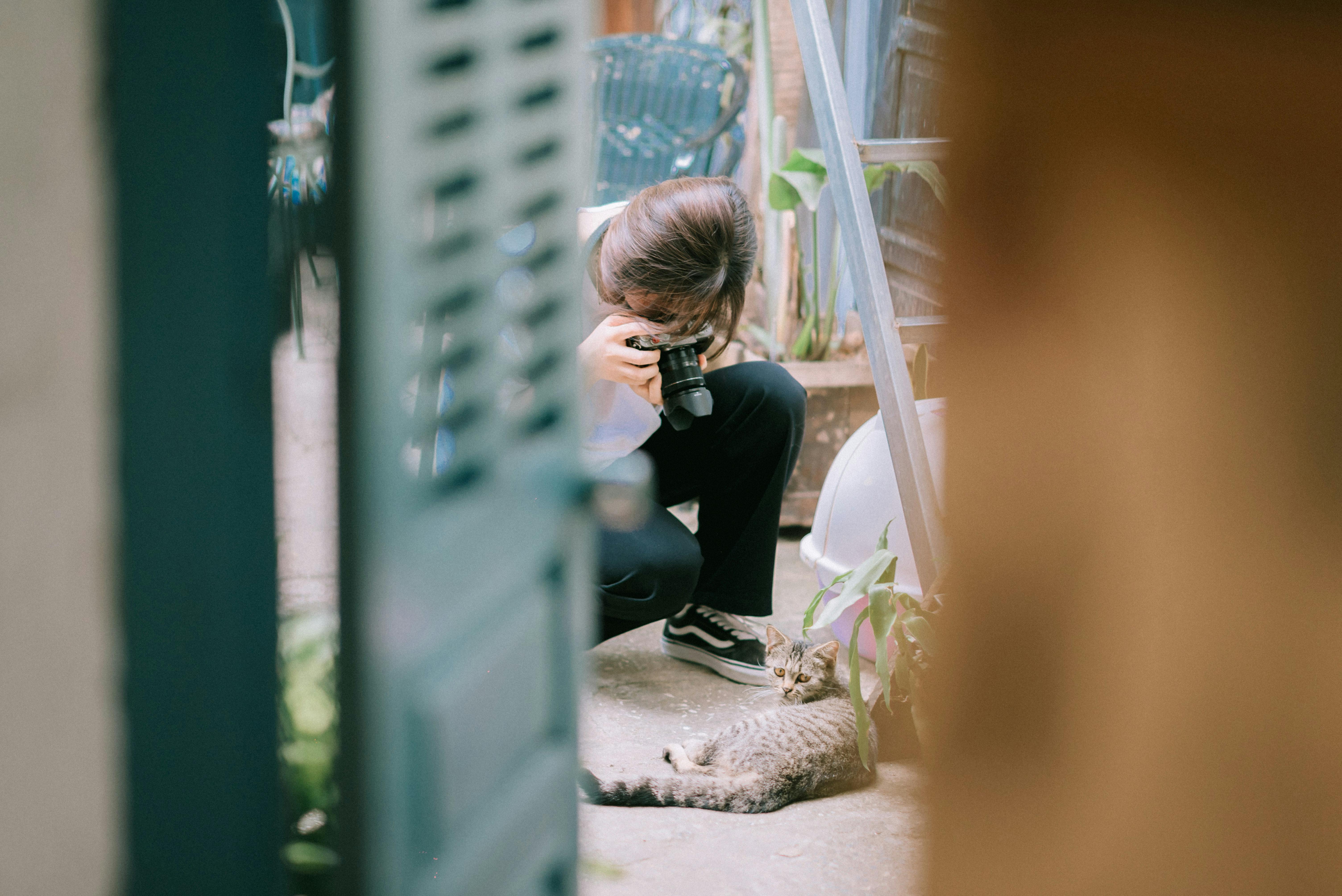 Woman Taking a Photo of a Cat