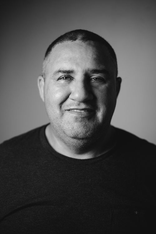 Free Studio portrait of a smiling man in casual attire, captured in black and white. Stock Photo