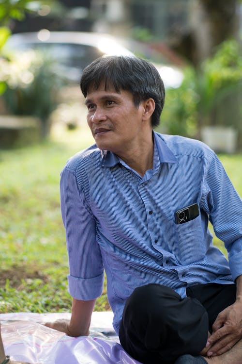 Portrait of a Man Wearing a Blue Shirt Sitting Outdoors