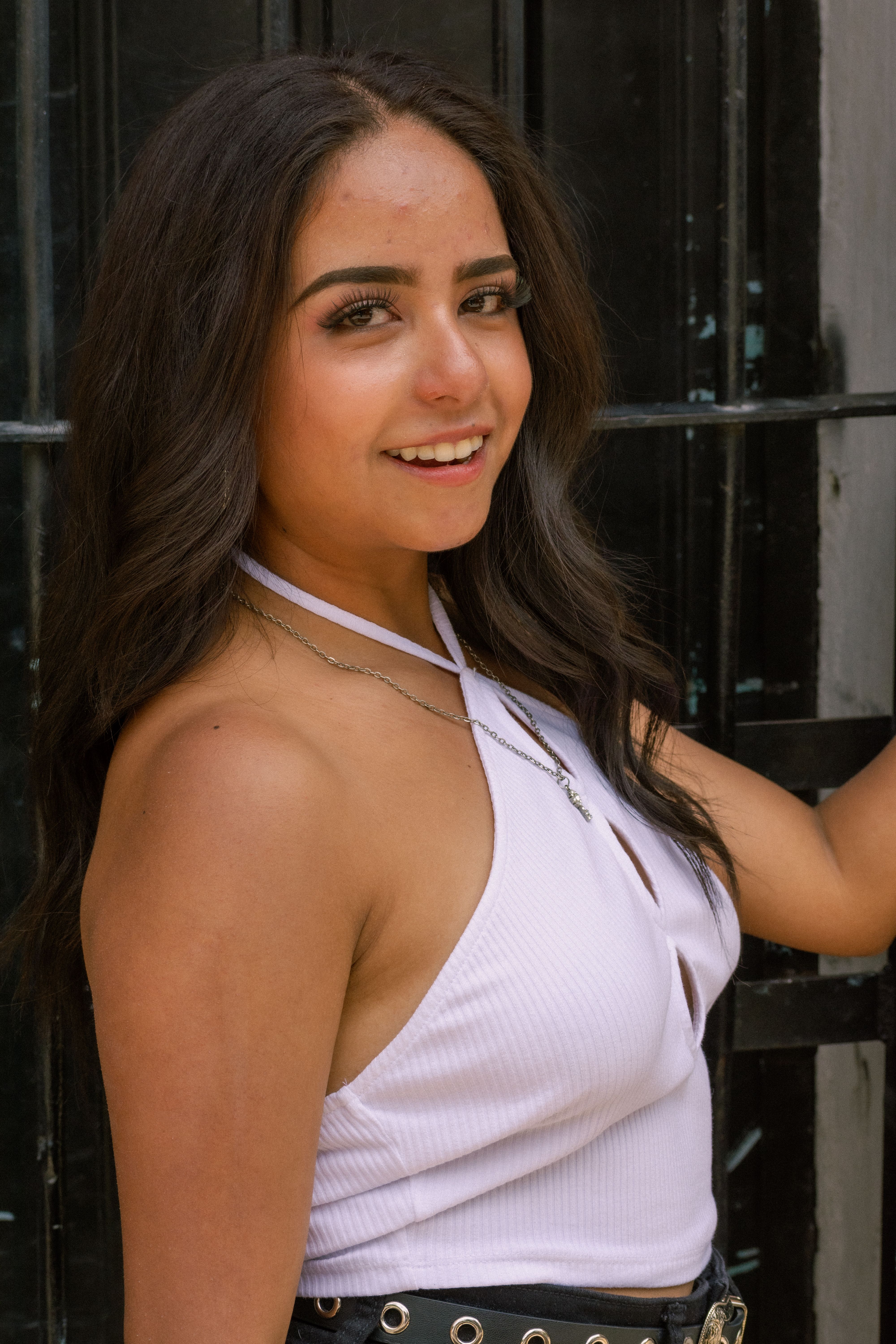 Charming portrait of a smiling young woman in a stylish white halterneck top.