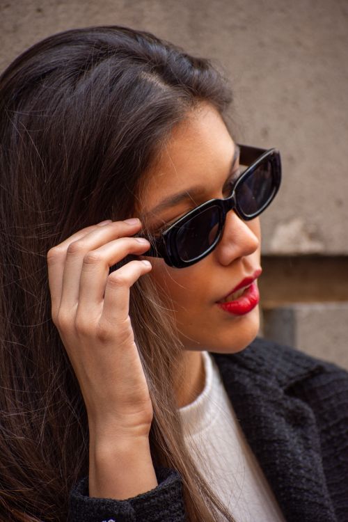 Free Fashionable close-up portrait of a woman in sunglasses and red lipstick, exuding glamour. Stock Photo