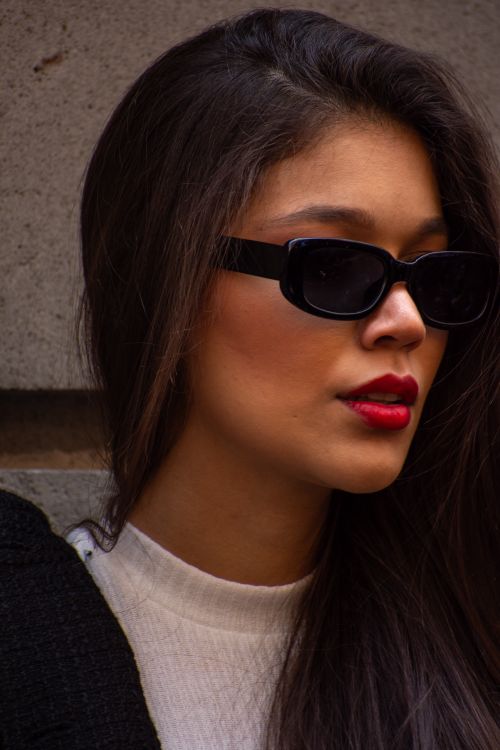 Free Stylish portrait of a woman wearing sunglasses and bold red lipstick, exuding fashion elegance. Stock Photo