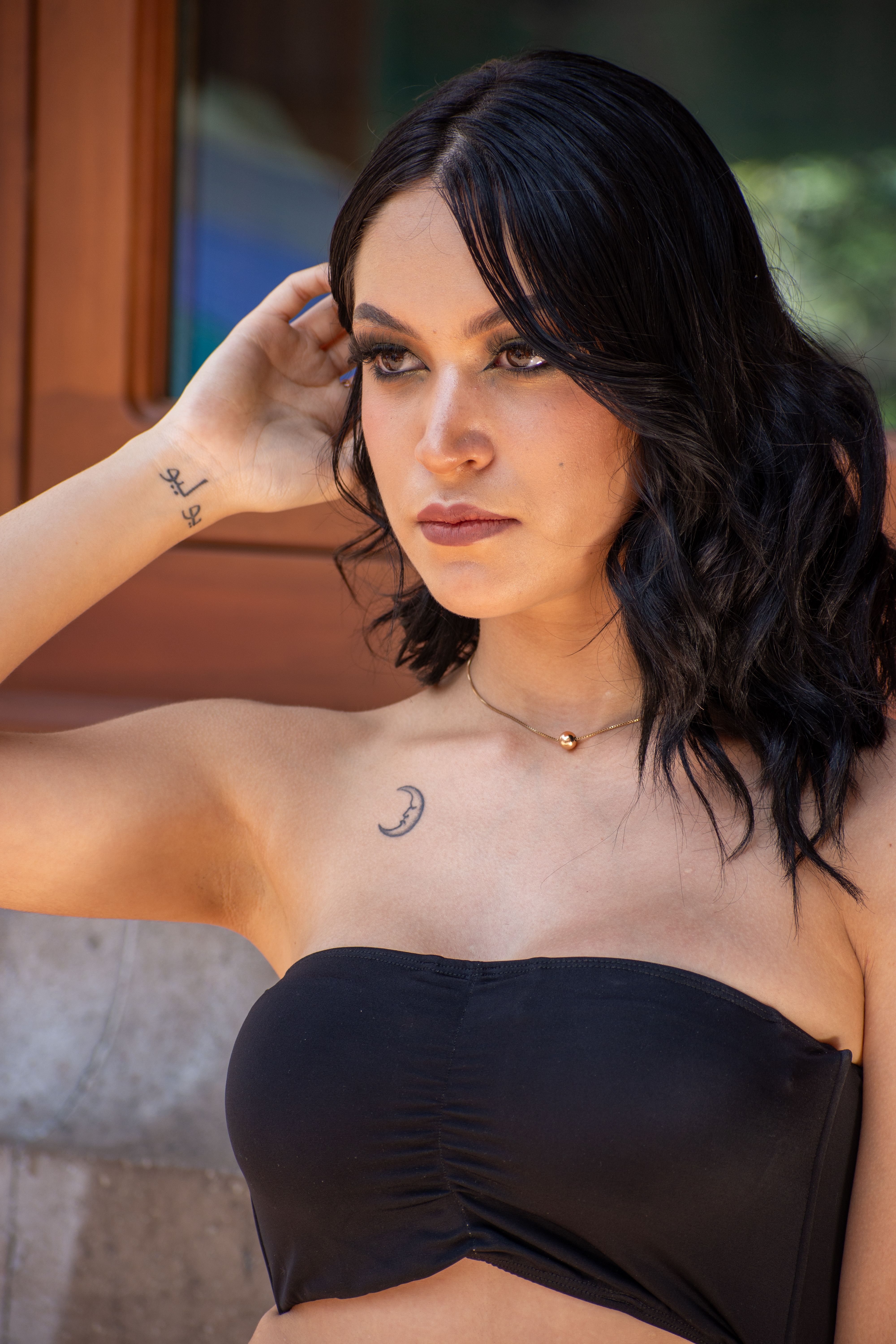 Stylish portrait of a young woman posing outdoors in an urban setting, showcasing fashion and elegance.