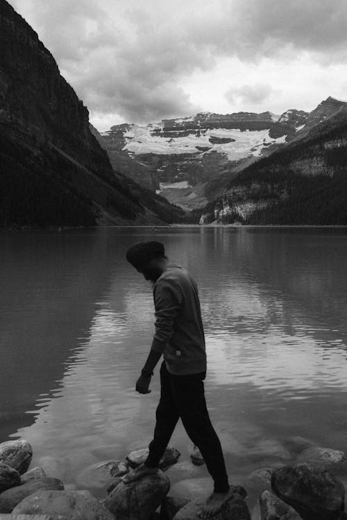 A man walking along the edge of a lake