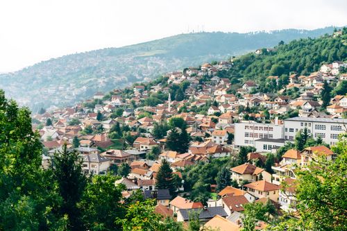 Free Scenic view of Sarajevo's hillside houses on a summer day, showcasing traditional architecture and lush greenery. Stock Photo