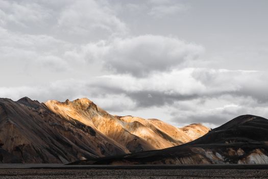Stunning view of rugged mountains under a dramatic cloudy sky, capturing natural beauty.