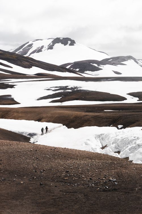 Free Two hikers exploring snowy mountains, capturing winter's serene beauty and adventure spirit. Stock Photo