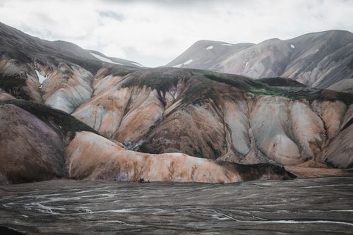 Free Stunning multicolored mountains in a barren valley with unique rock formations under a cloudy sky. Stock Photo