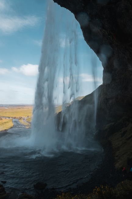 Dramatic view of a waterfall with a natural arch, perfect for nature-focused concepts.